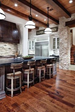 High-low+finishes+such+as+a+distressed+copper+range+hood%2c+a+gleaming+stainless+fridge%2c+rough-hewn+ceiling+timbers%2c+and+dark+wood+floors+help+compose+a+look+that%27s+both+industrial+and+warm.