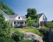 A new barn/garage and a reworked ell shift the focus of this house toward a lushly landscaped side yard.