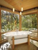 In the southwest corner, an oval tub sits in a steel frame with a laser-cut pattern resembling vine runners, which is repeated on the valances.
