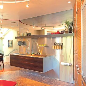 Now you see it, now you don't: A built-in composter is hidden beneath the custom cutting board and the mirror above the sink becomes a TV screen at the flick of a switch.