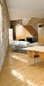 The free-standing island closest to the window wall has deep drawers on the interior side for dinnerware; the back is left open for counter seating that addresses the kitchen and living room. The other island houses appliances and extra storage on the liv