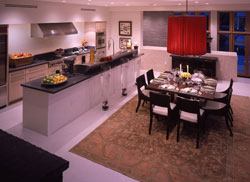 The efficient but well-appointed kitchen hides its utility without blocking views or hindering access to the casual dining area and spaces beyond. A butler's pantry to the left of the refrigerator provides additional storage.