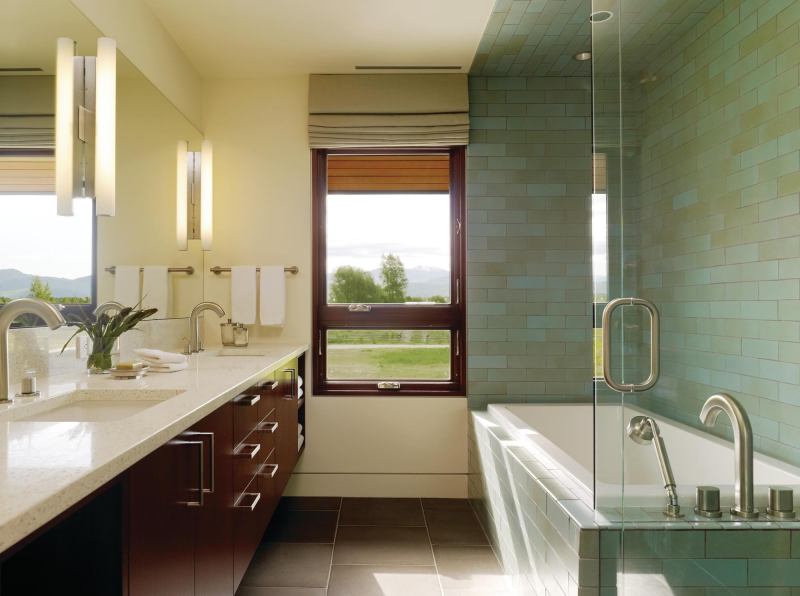As in the master, the bathing area in the children's bath is defined by ceramic tile in a running bond pattern. The transparent shower surround occupies little apparent space, virtually disappearing against the darker tile.