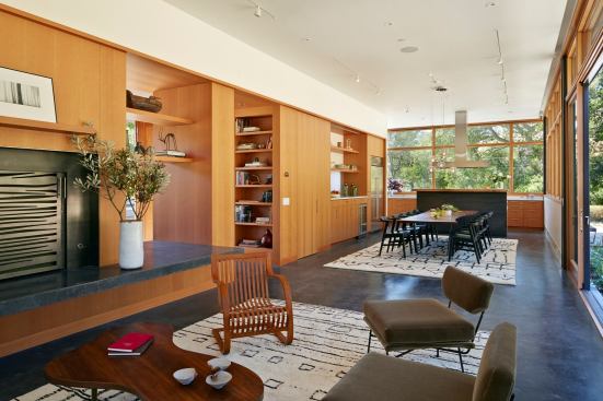 A wall paneled in douglas fir integrates the great room’s sitting, dining, and cooking areas.