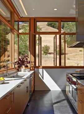 The kitchen occupies one end of a great room that includes spaces for cooking, dining, and gathering.