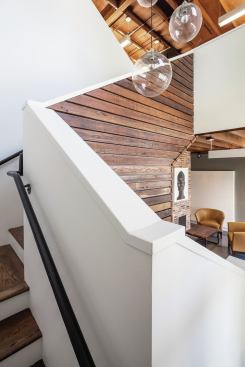 Interior framing, walls, and stairway reuse the home’s original wood framing.