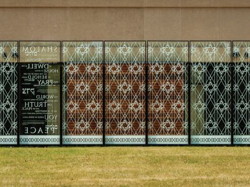 Each panel is framed in bronzed anodized aluminum and set on steel footings. The bronzing matches window mullions in the existing building. 