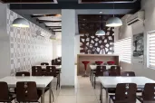 Situated in an old warehouse, the café uses salvaged materials and furniture to minimize costs
