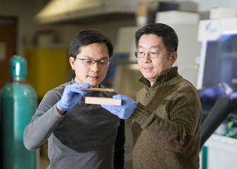Scientist Liangbing Hu (left) holds a block of wood transformed by a new process to become tougher than steel. Teng Li (right) holds an untreated block of the same wood.