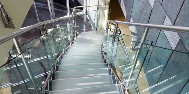 A cantilevered stainless stair with glass treads joins the second and third floors.