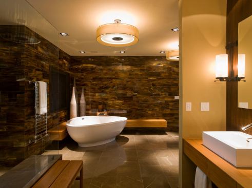 The aim was a spa-like feel throughout the bathroom, so the redo included walnut, teak, glass tile, and soft lighting. The tub itself is a rounded triangle that nestles into a corner formed by teak benches. Specially-built teak housing accommodates the tub’s custom-built faucet. Designer: Mark Cravotta Builder: David Wilkes Builders