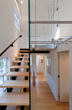 Open-tread stairs lead to the third-floor bedroom.