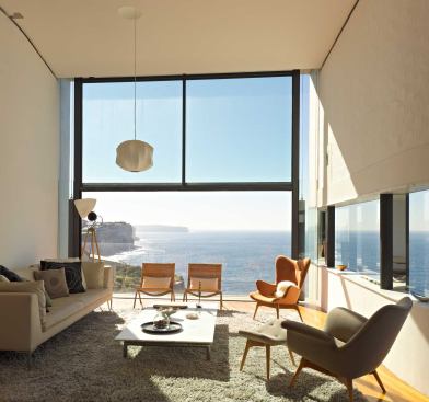 A pair of cable-hung weights counterbalance the living room window’s operable lower sash. A nearly invisible glass guardrail stands just outside.