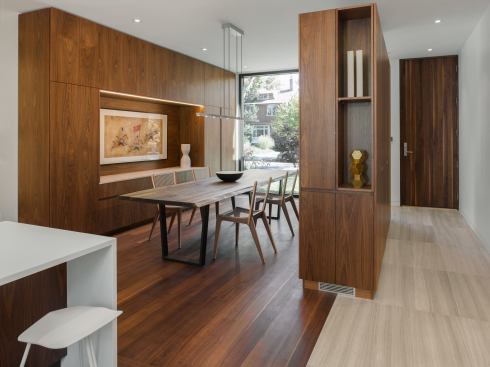 A closet element of walnut millwork delineates the front entry hall from the dining room without walling off the two spaces.