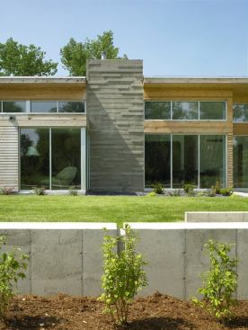 Board-formed concrete gives the chimney a masonry-like textural rhythm.