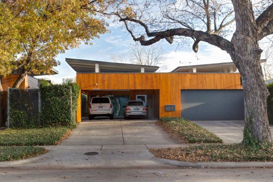 When closed, the garage doors provide security and privacy as part of a contextual yet modern façade. Once open, however, the crushed rock parking pad becomes a public gathering space with a whimsical parasol roof and an open side wall facing an ivy-covered fence.