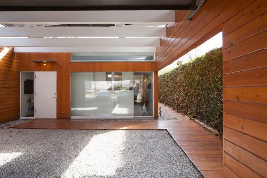 Opening the garage door transforms the car court into a street-facing outdoor space. An oversized “front porch” is how Baum conceived it. Placing the kitchen just inside the front door makes it easy to grab food or drink and head outside to the covered court. “Even when it rains,” Baum explains, “the sound is great on the metal roof where rigid insulation means that each drop makes a gentle thud.”