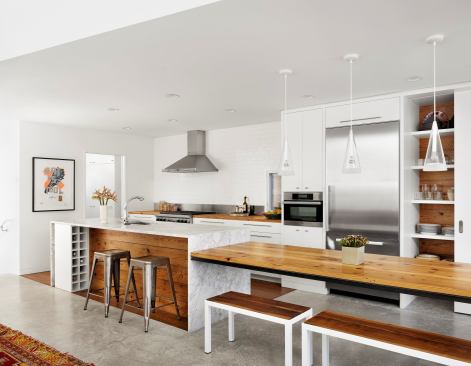 The galley layout is centered around a work island. Long-Leaf pine from the original home's floor joists, was used for the island's dining table and recessed panel, playing against the white marble.