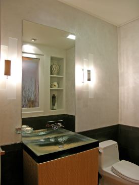 A resin inset lets light into this tiny powder room. Storage shelves add depth and interest, and a glass sink adds texture. Project: Oakland House, Oakland, Calif.; Architect: Jason Kaldis, Berkeley, Calif.; Builder: Whitney Collins, Whitney Collins Builders, Oakland, Calif.