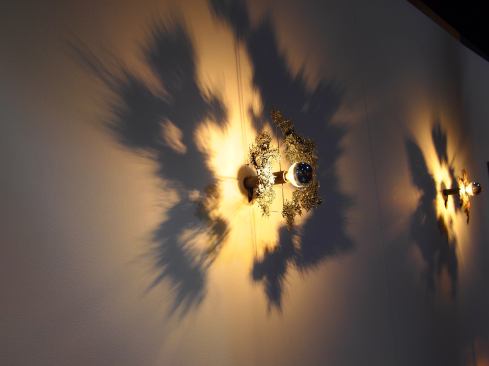 This metal wall sconce resembles falling autumn leaves.