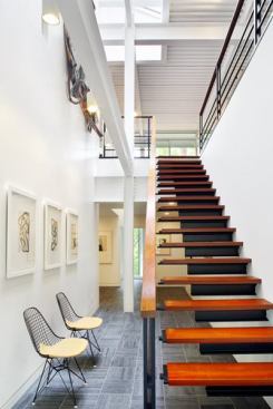 Steel I-beams, welded to a steel stringer hidden in the wall, support stair treads of Brazilian cherry.