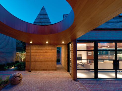 Familiar forms, such as the bath volumeís steeply pitched roof, eschew overhangs and gutters.