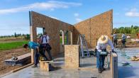A TC Legend Homes crew stands a SIP frame.
