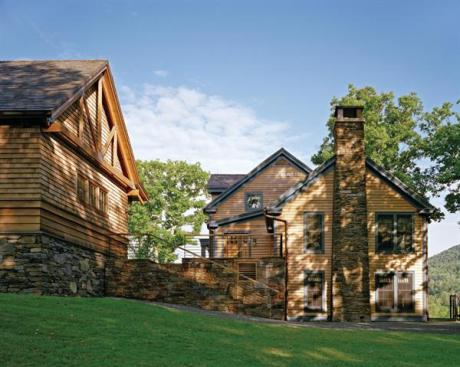 Dark blue painted trim on the house now sporting a cedar roof and siding distinguishes it from the other buildings. 