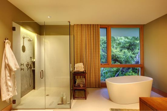 The tub sits like an oversized teacup in the bathroom of this Florida home. Though the vibe and detailing are minimalist, there’s warmth as well. Architect: Jerry Sparkman, Totems Architecture Builder: Michael K. Walker