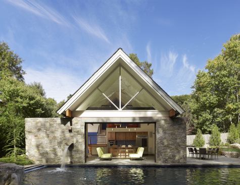A dry-stacked stone wall draws a thin line between this pool and its accompanying house. The wall also houses the piping by which the pool is fed, and the sound of rushing water from a built-in fountain helps preserve privacy on this tight lot. Project: Pool + House, McLean, Va.; Builder: Gruver and Cooley, Leesburg, Va.; Architect: Randall Mars Architects, McLean; Landscape architect: Surrounds Landscape Architecture, Herndon, Va.