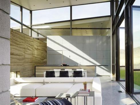 The kitchen area consists of a wall of lacquered cabinets and a stainless steel island.