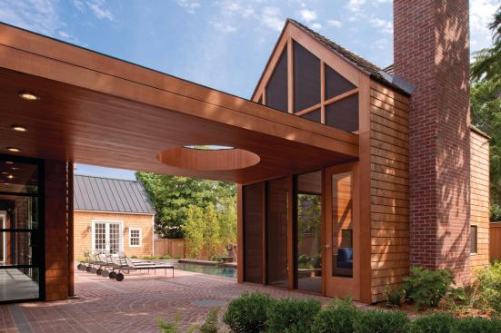 A circular aperture marks passage between the living area and screened porch.