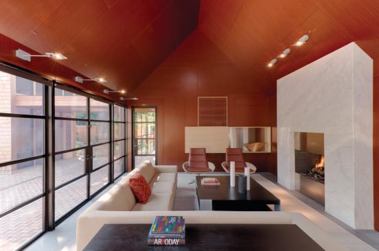 The kitchen/living pavilion has mahogany walls and ceilings, basalt flooring, white marble counters and fireplace, and stainless steel cabinetry.