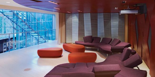 The second-floor entertainment area opens onto the living spaces below-until the curtain is drawn and a viewing screen descends from the ceiling. A folded wall of perforated stainless steel panels conceals the audio/video equipment.