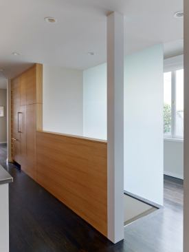 The stairwell's solid walls were either cut in half or replaced with glass which allows light to penetrate all the way to rear of the home.