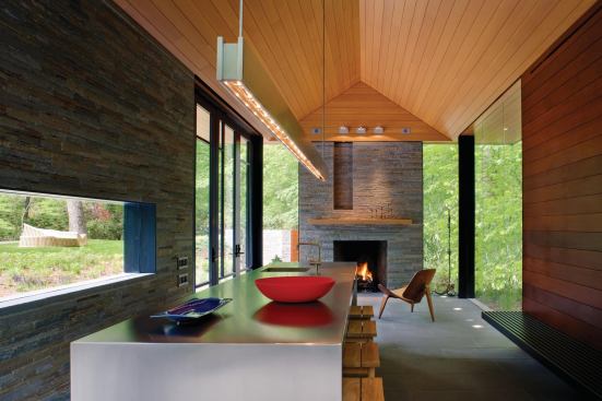 Pivoting doors open the pavilion in summertime; in winter a Rumford fireplace and heated floors warm the space.
