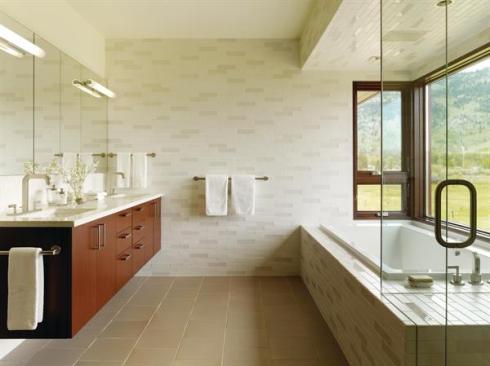 The master bath devotes its outside wall to a tub-and-shower bay, with the tubs tiled deck becoming a bench where it enters the shower enclosure.