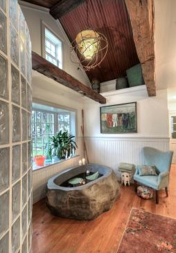 This 5,500-pound, solid granite tub was an eBay find that the homeowners fell in love with. A challenge? You bet. Floor boards were scribed two to three times to make sure they fit perfectly around the massive focal point. The lower third of the tub is below floor and wrapped in a radiant loop. Designer/Builder: Jarrett Kravitz, Advantage Contracting
