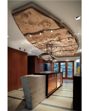 The cooking side of the island is straight, while the opposite side is curved, allowing for maximum wheelchair mobility within a narrow galley footprint. Above the island is a maple ceiling panel whose design was inspired by boiilng water.