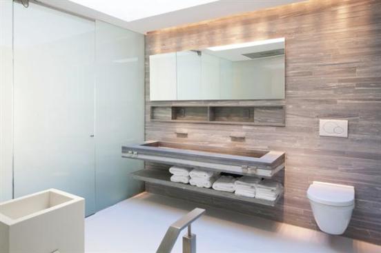 A+custom+vanity+features+a+wide+trough+sink+and+shelves+for+towels.