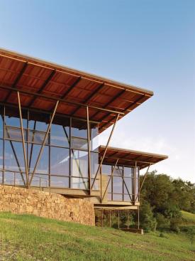 The central pavilions steel frame cantilevers over a curved retaining wall