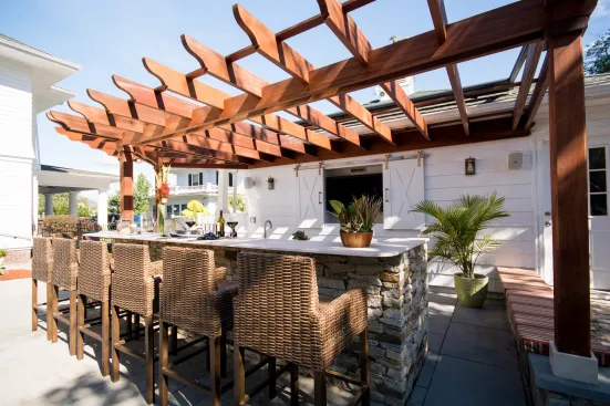 Fall River: Rhode Island–based firm Insperiors transformed this traditional New England backyard into a complete outdoor living space with an array of stainless steel appliances, bar-height seating, and a lounge area for a family of five.