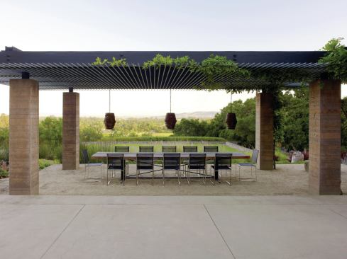 Composed of board-formed concrete columns, a gravel floor, and a repurposed pipe ceiling, the dining pavilion frames views of the foothills.
