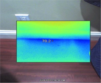 The infrared camera captures this view of air leakage at the base of a wall during a blower-door test.