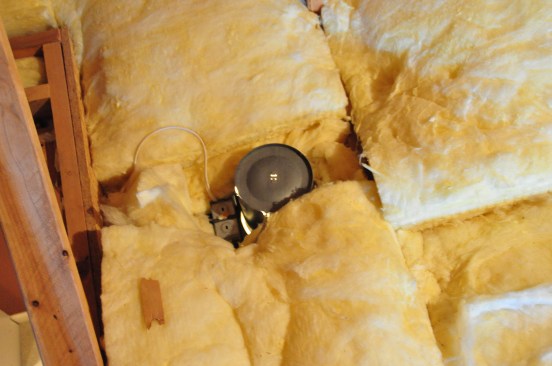 Recessed light fixtures are a major source of air leaks into attics. Here, light is shining up through the can light from below.