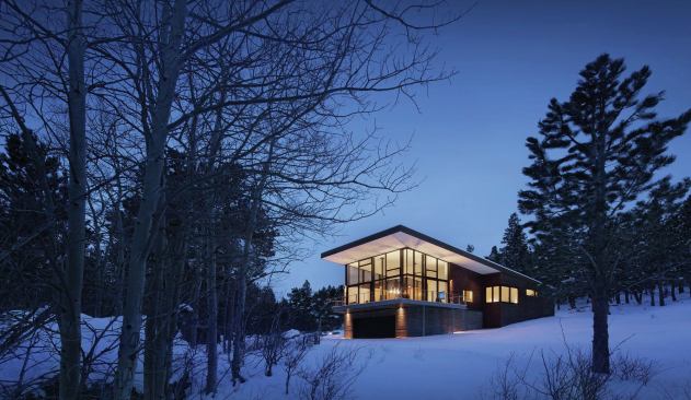 The white plaster ceiling and exterior-plaster soffits creates the appearance of a continuous, monolithic surface at the roof’s underside.