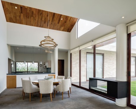 Windows and sliding glass doors in the kitchen and dining area open the house to a grassy courtyard