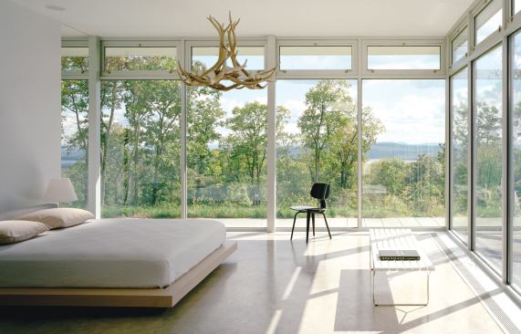 Perched at the edge of a steep slope, this weekend home arrays its primary living spaces—both indoor and outdoor—to capture the view.