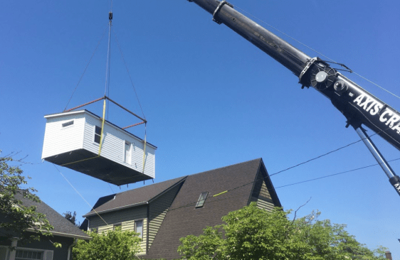 Construction crews crane a Dweller ADU into place in Portland, Ore.
