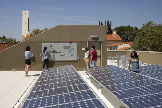 Flat roofs clad with cool roof thermoplastic membranes support PV arrays, rooftop gardens, and eco-classrooms.  